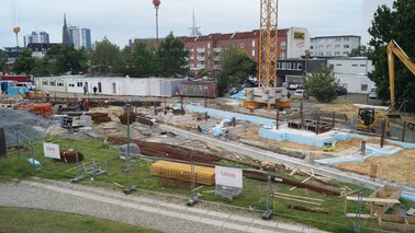 Eingezäunte Baustelle mit Baucontainern, diversen Baumaterialien und ersten Isolierten Fundamenten | © Jobcenter Bremerhaven
